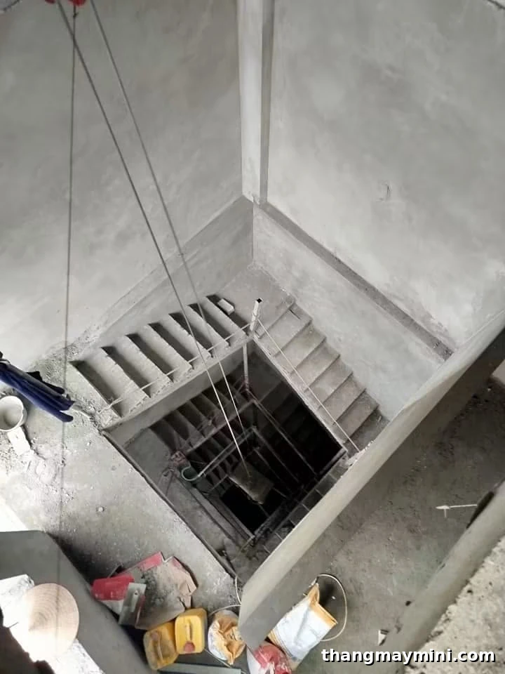 Giếng thang máy đặt giữa lòng cầu thang bộ trong nhà cải tạo đang thi công