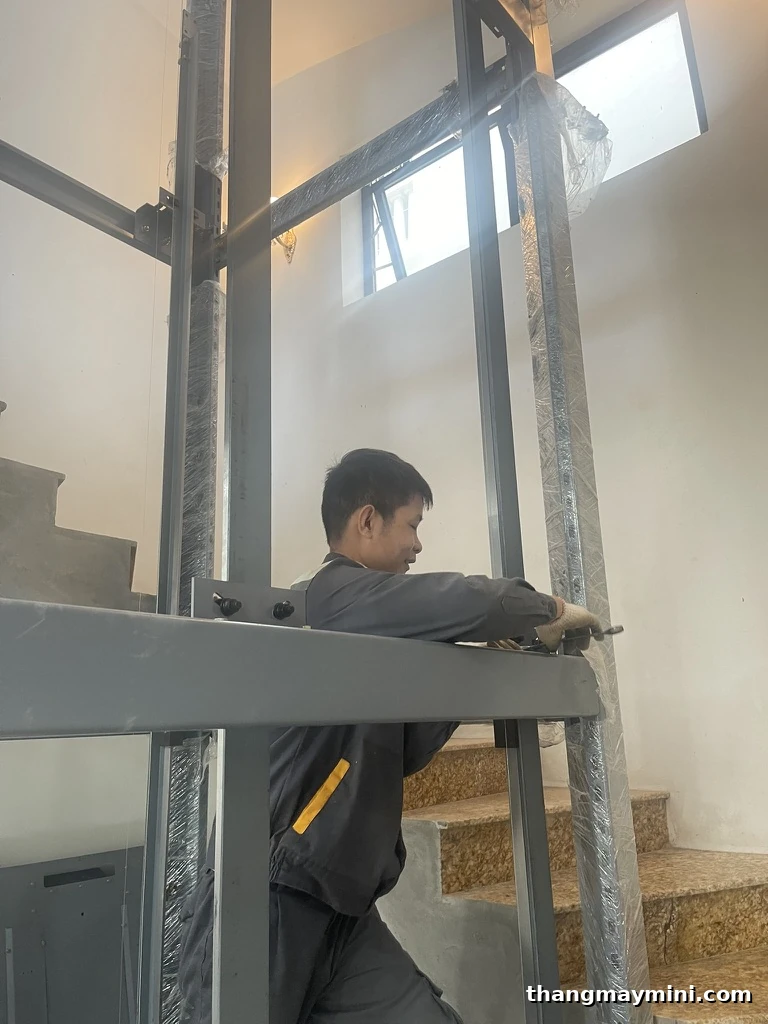 Kỹ thuật viên thi công khung thép giếng thang máy cho nhà cũ cải tạo